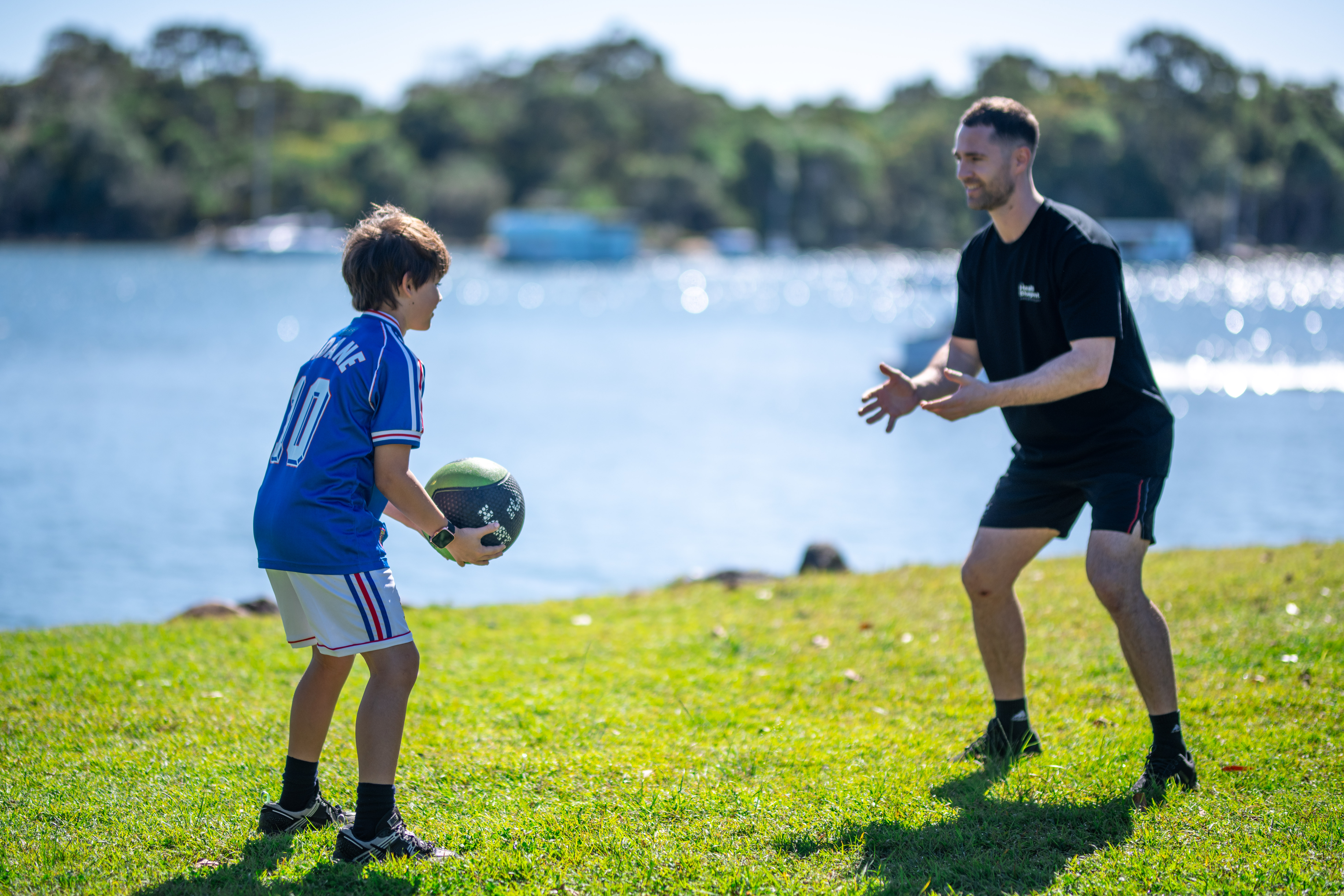 Isaac McCrimmon, Accredited Exercise Physiologist, working with a child outdoors by the river
